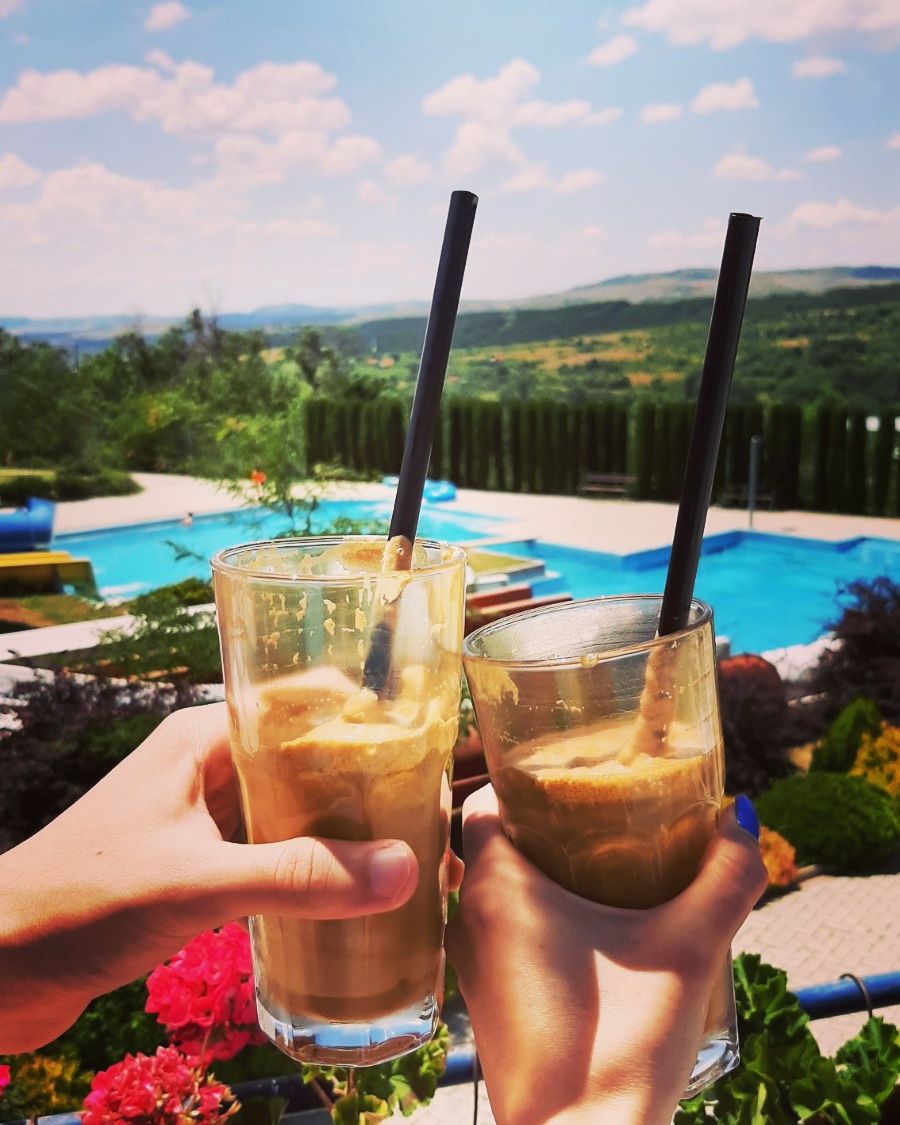 two glasses with coffee with a view towards pools